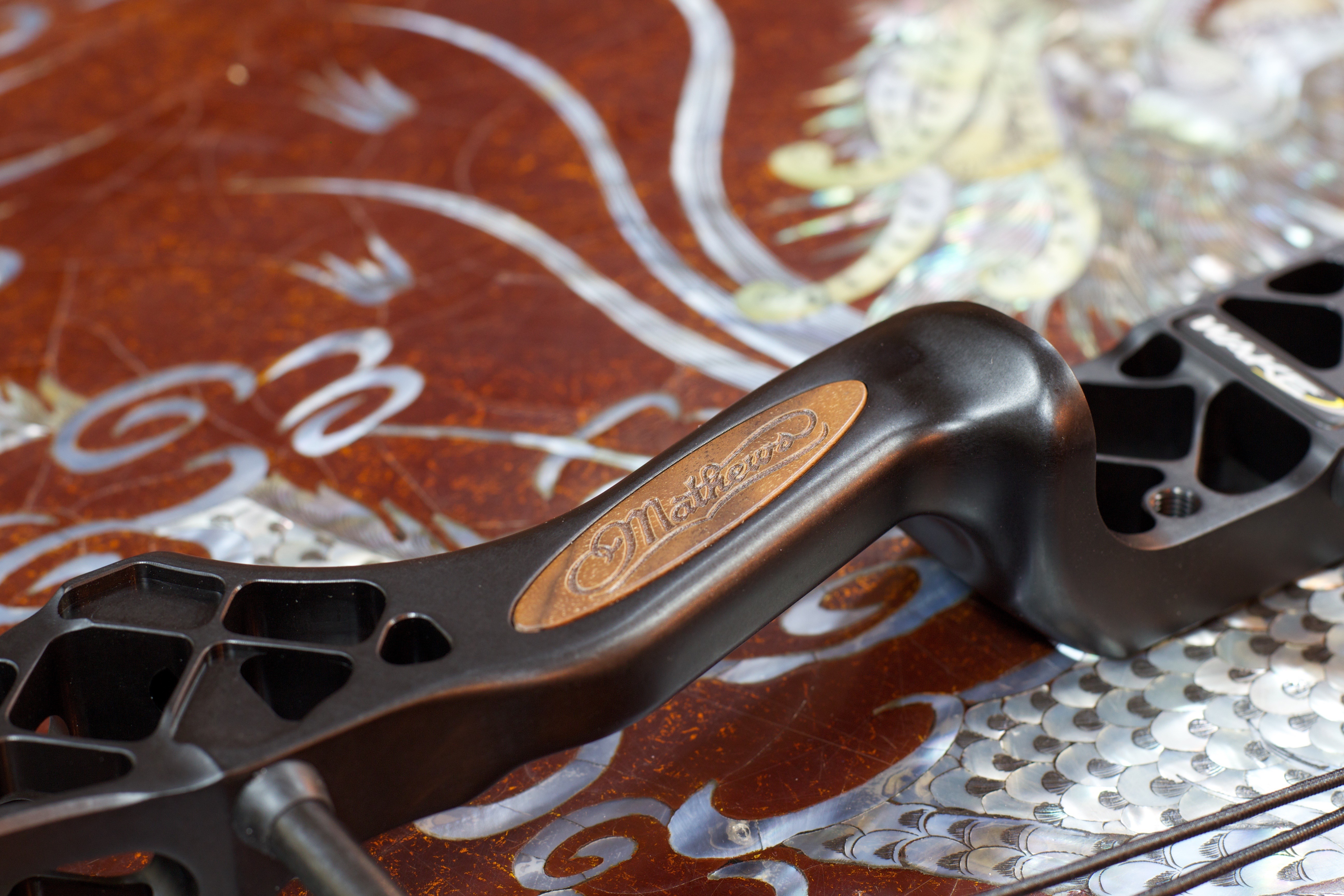 Анодированная поверхность райзера и вставка из дерева с логотипом Mathews